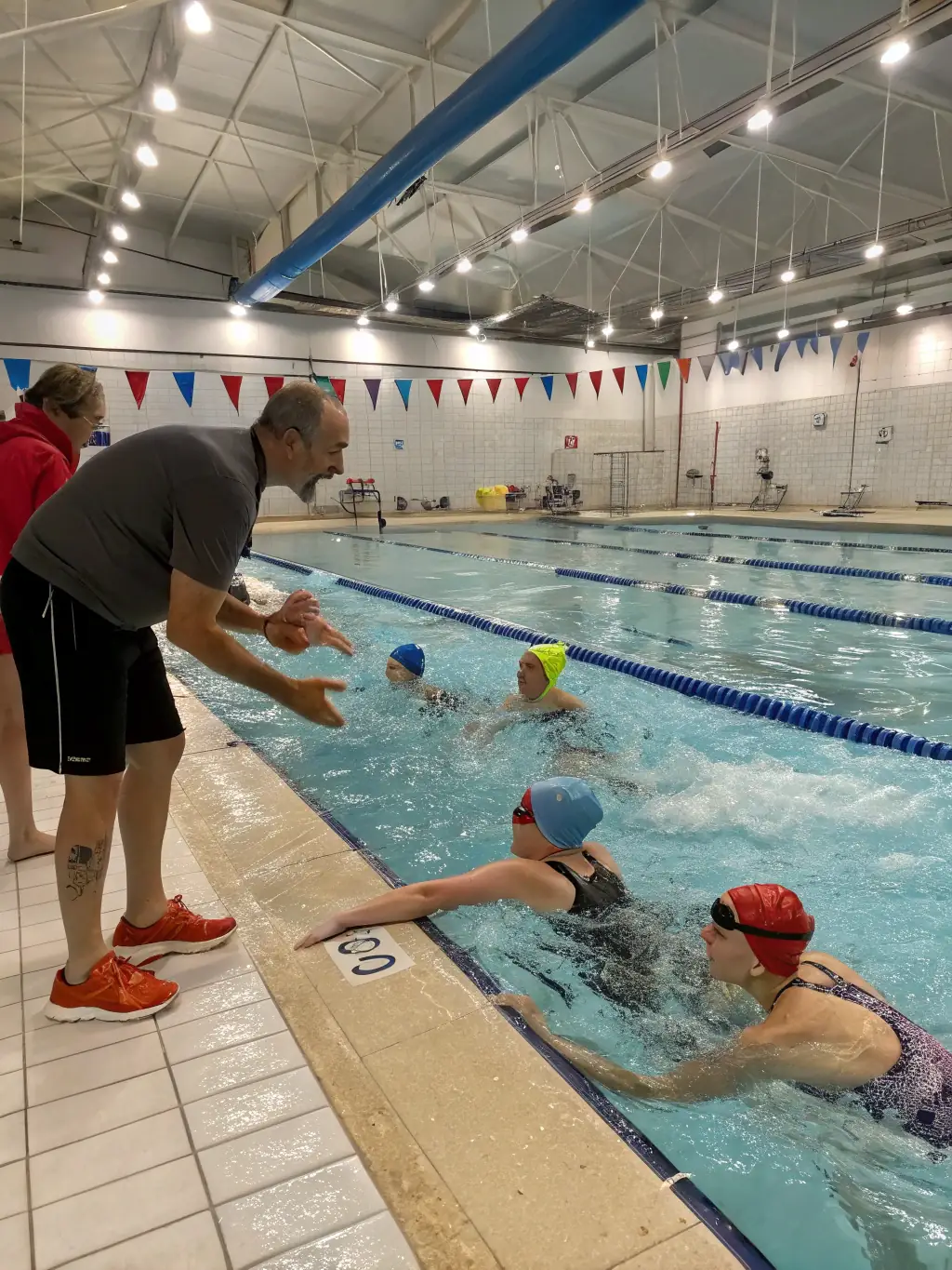 Swimmers of various ages and abilities participating in a swimming lesson at a local pool, highlighting the inclusive swimming program of Vigilante Omnisports Mayet.